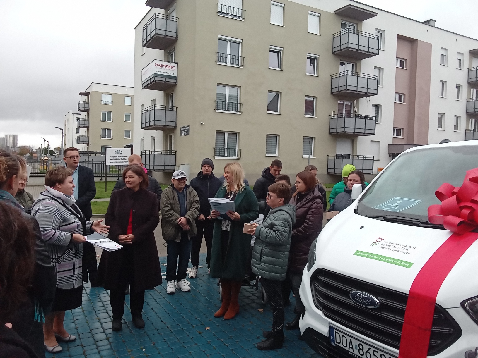 Zdjęcie: przedstawiciele Stowarzyszenia Tęcza, oddziału PFRON oraz powiatowych i gminnych jednostek wraz z zakupionym autem