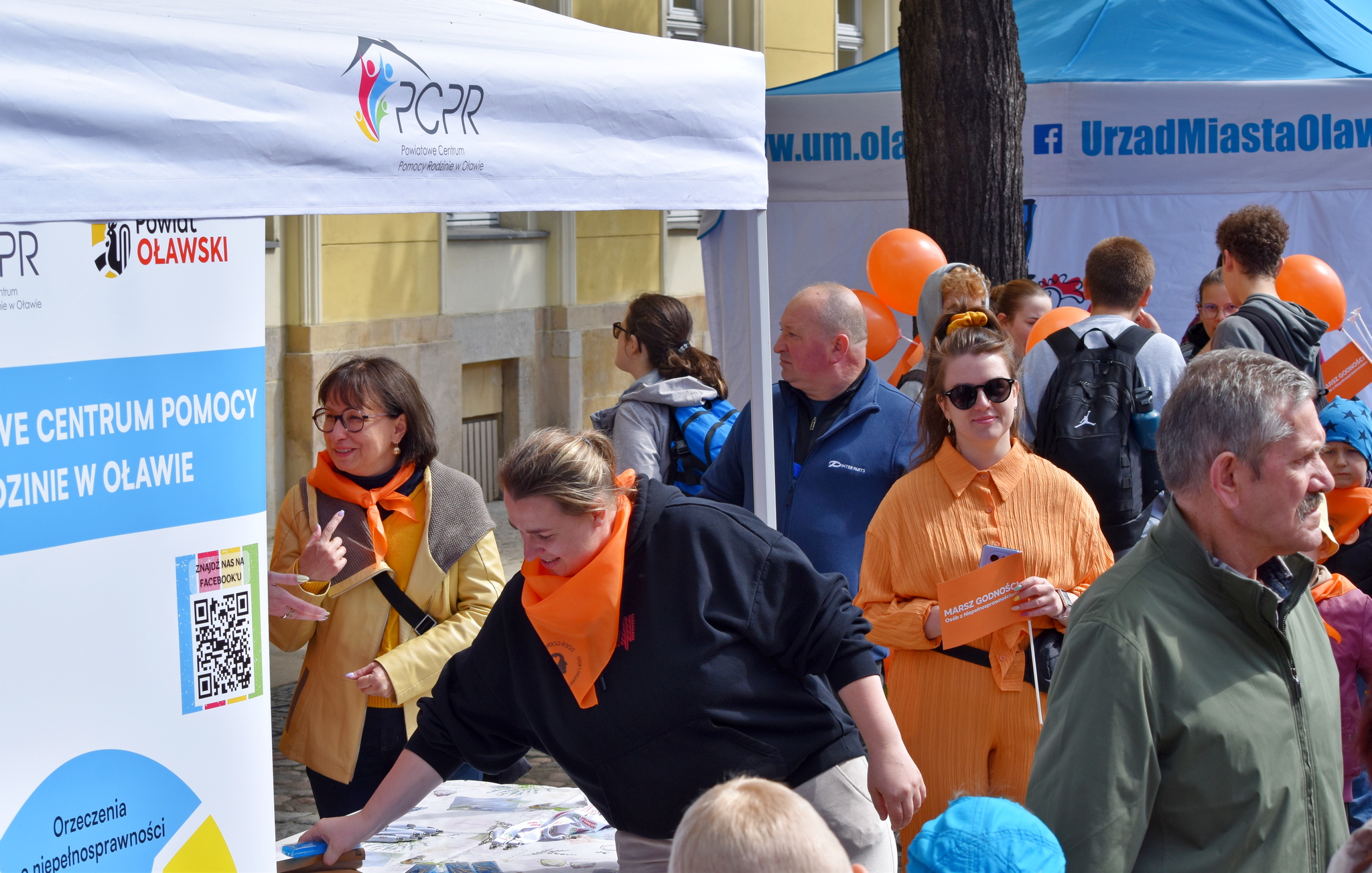 zdjęcie: stoisku PCPR wraz z banerem, dookoła osoby biorące udział w marszu